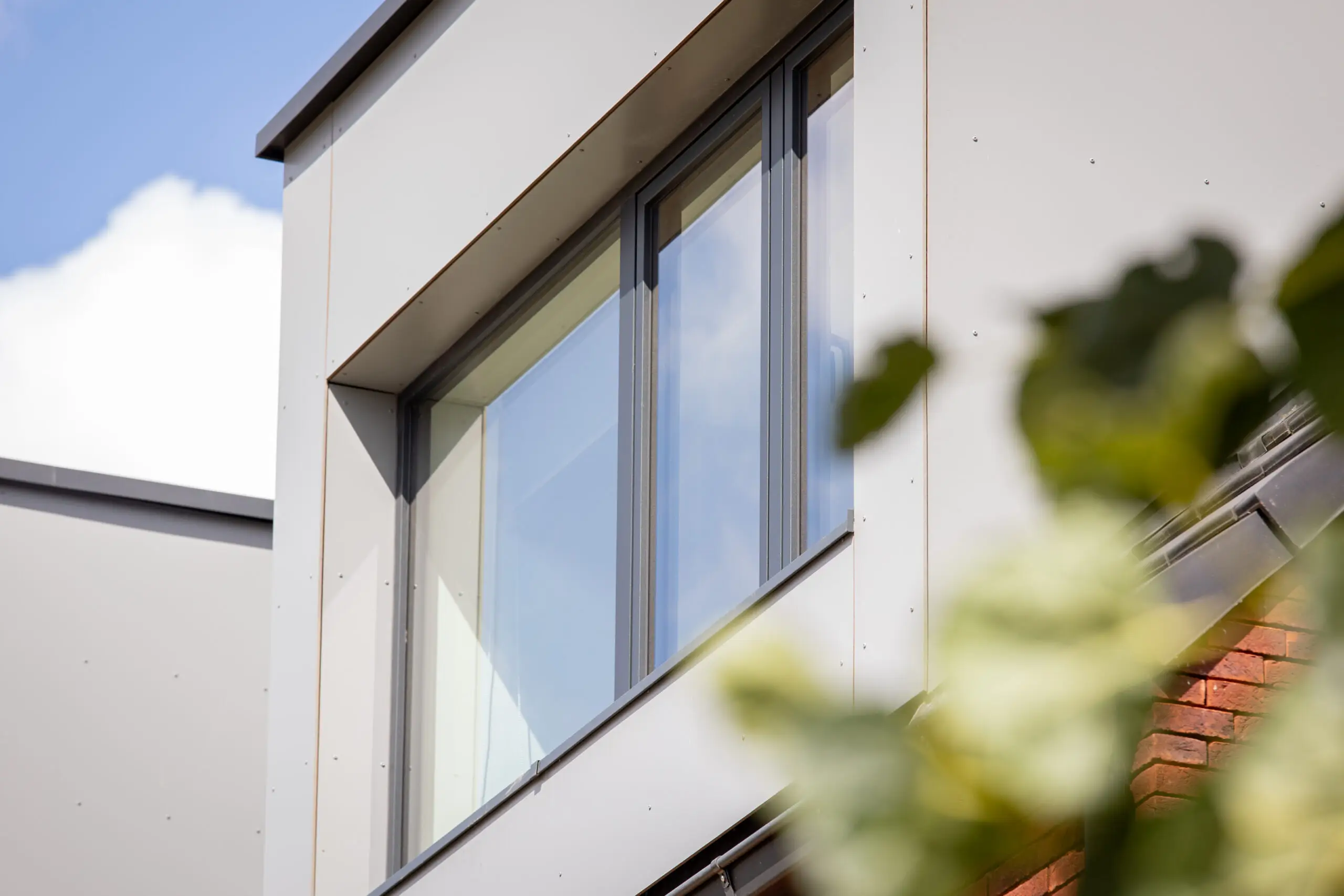 Donkere raamprofielen in de lichte gevel van een moderne woning
