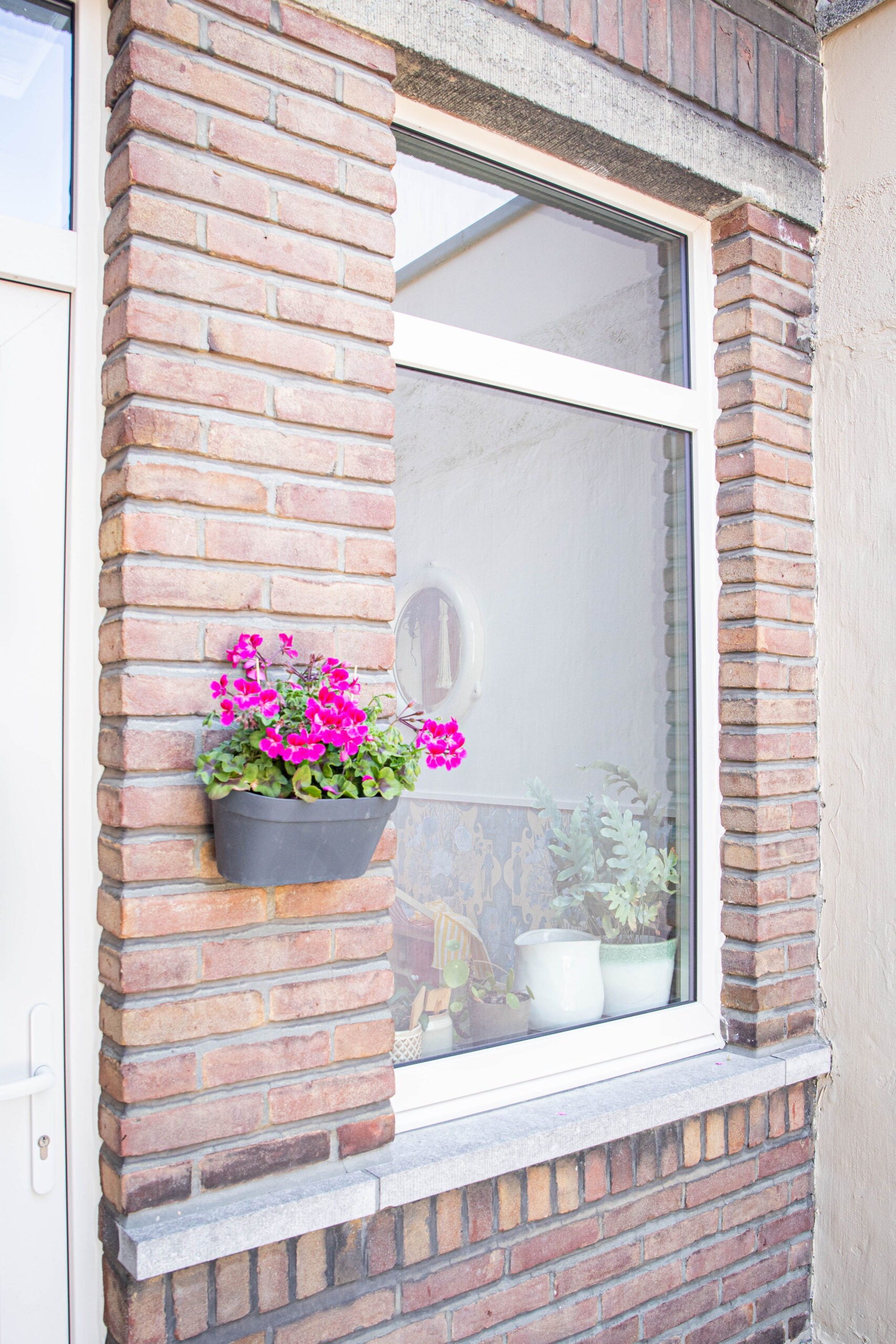 Wit Kömmerling renovatieraam in bakstenen gevel