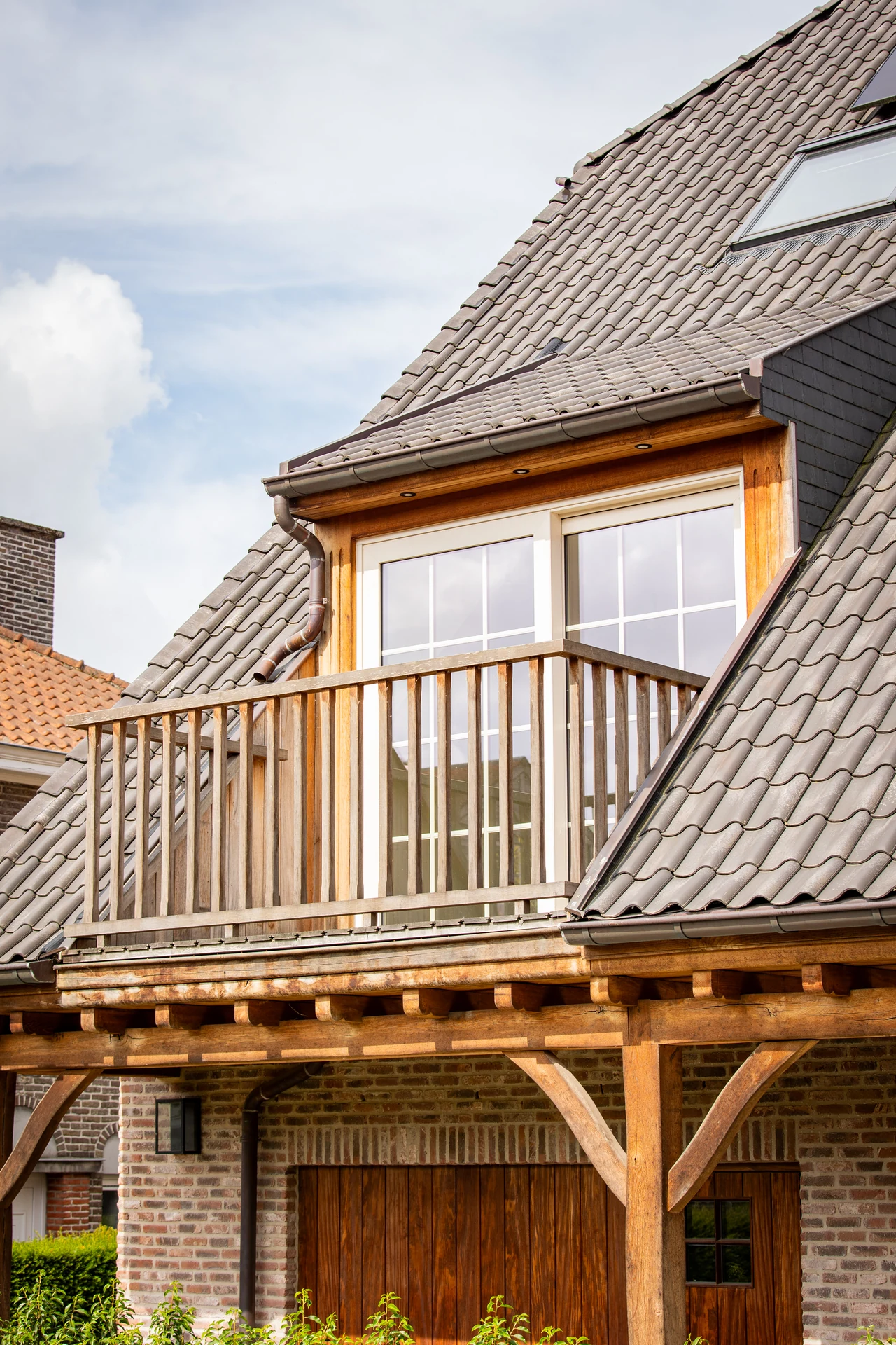 Balkon met dubbele glazen deuren onder een hellend pannendak