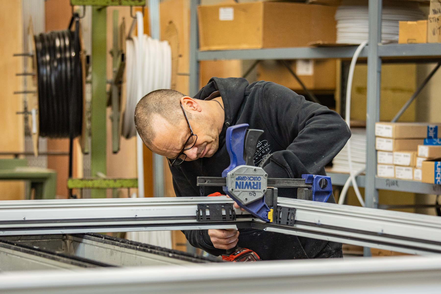 Medewerker werkt aan een raam in de werkplaats van Callplast