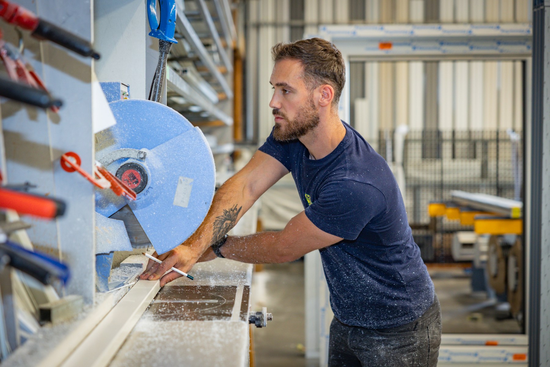 Vakman bij de bewerking van een raamprofiel in de werkplaats van Moeys